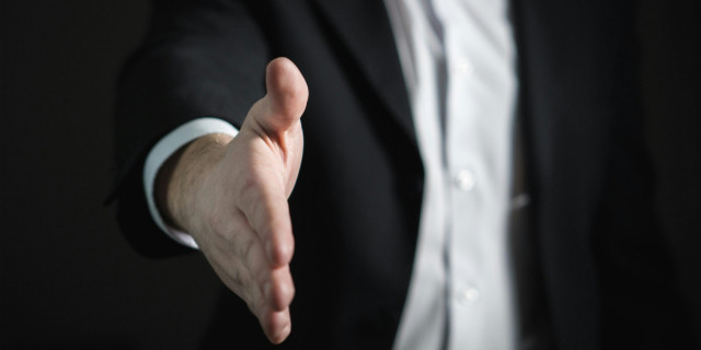 hand extended to shake (detail).