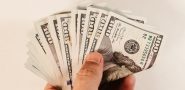 person holding 100 dollar bills.
